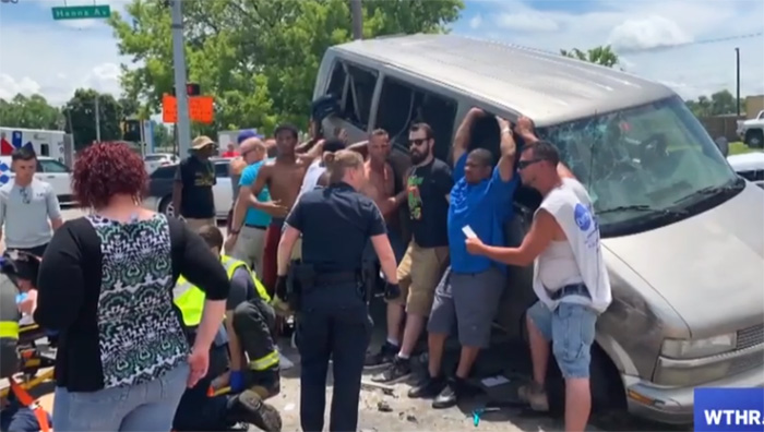 Dozens of people come together to lift van off a woman trapped under it after a car crash